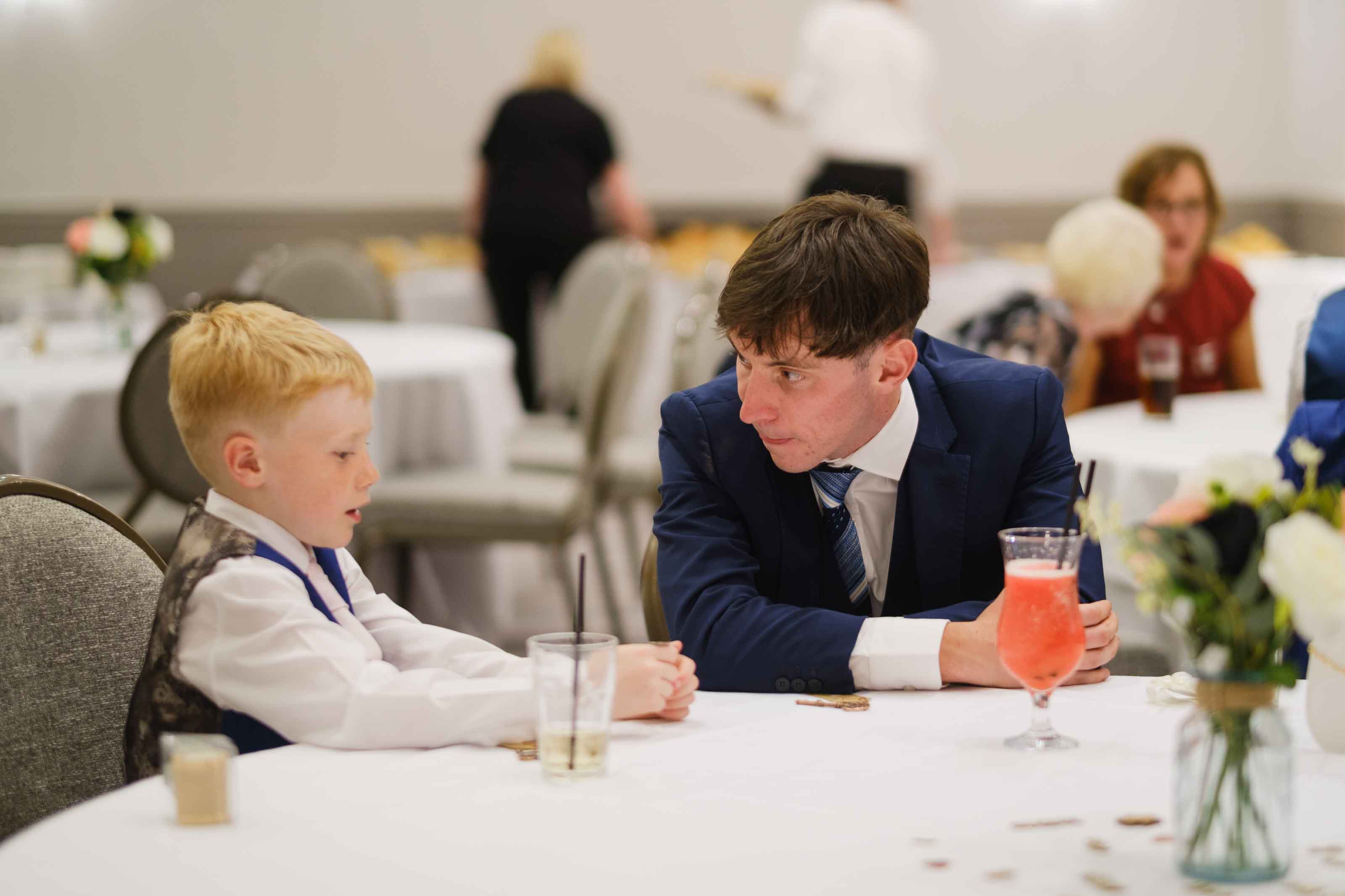 Wedding guest and child playing heads or tails during reception