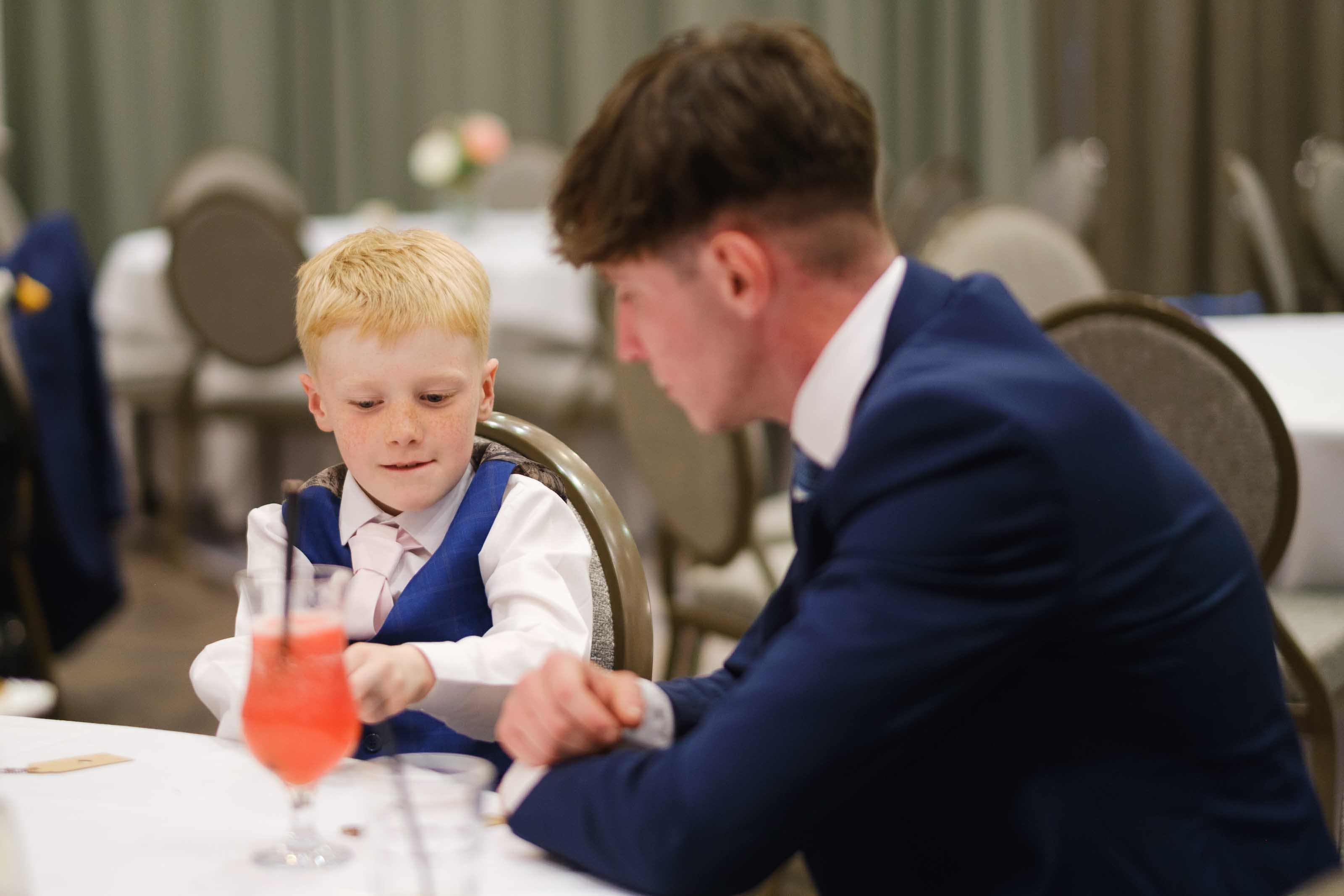 Wedding guest and child playing heads or tails during reception
