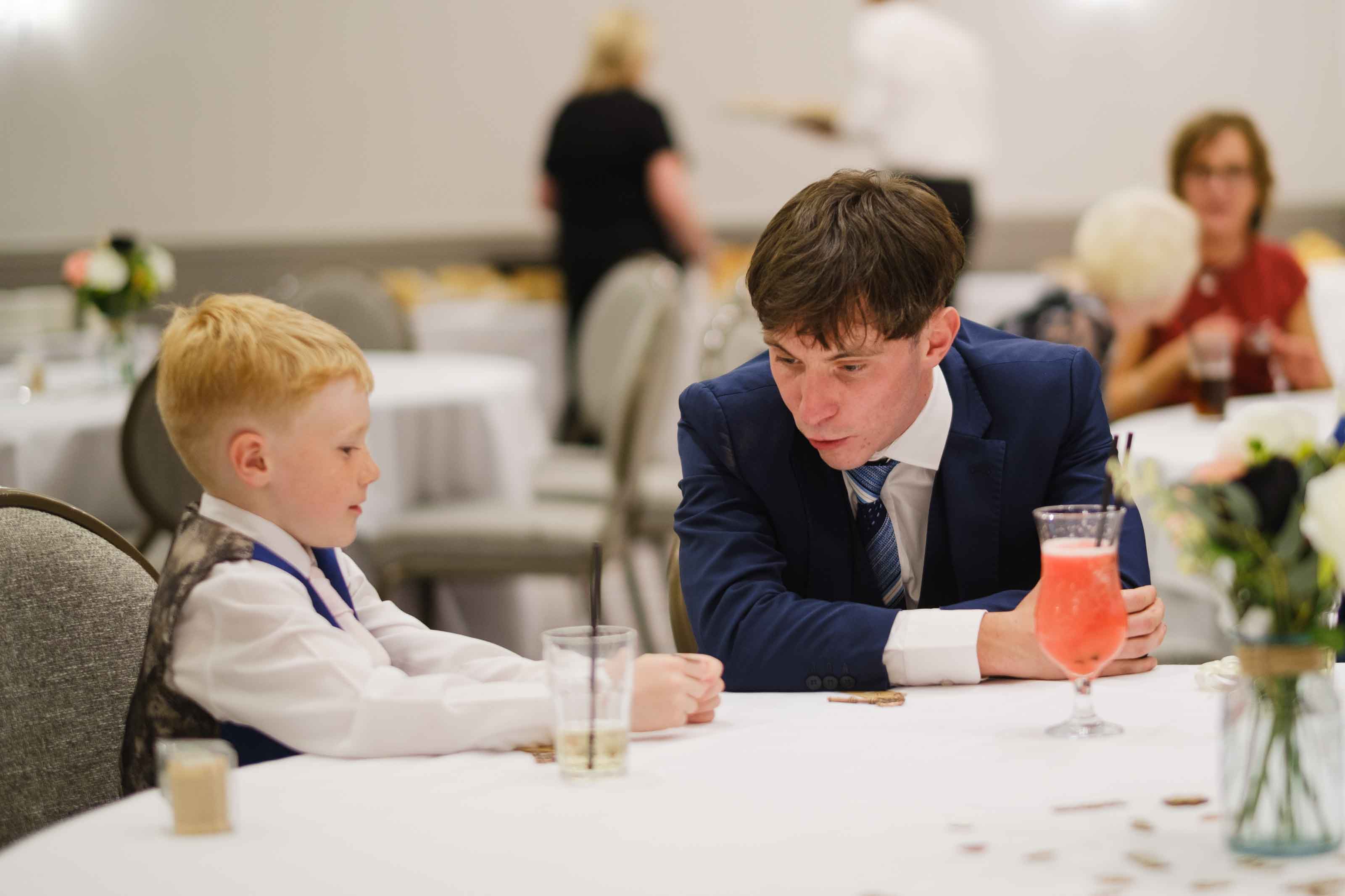 Wedding guest and child playing heads or tails during reception