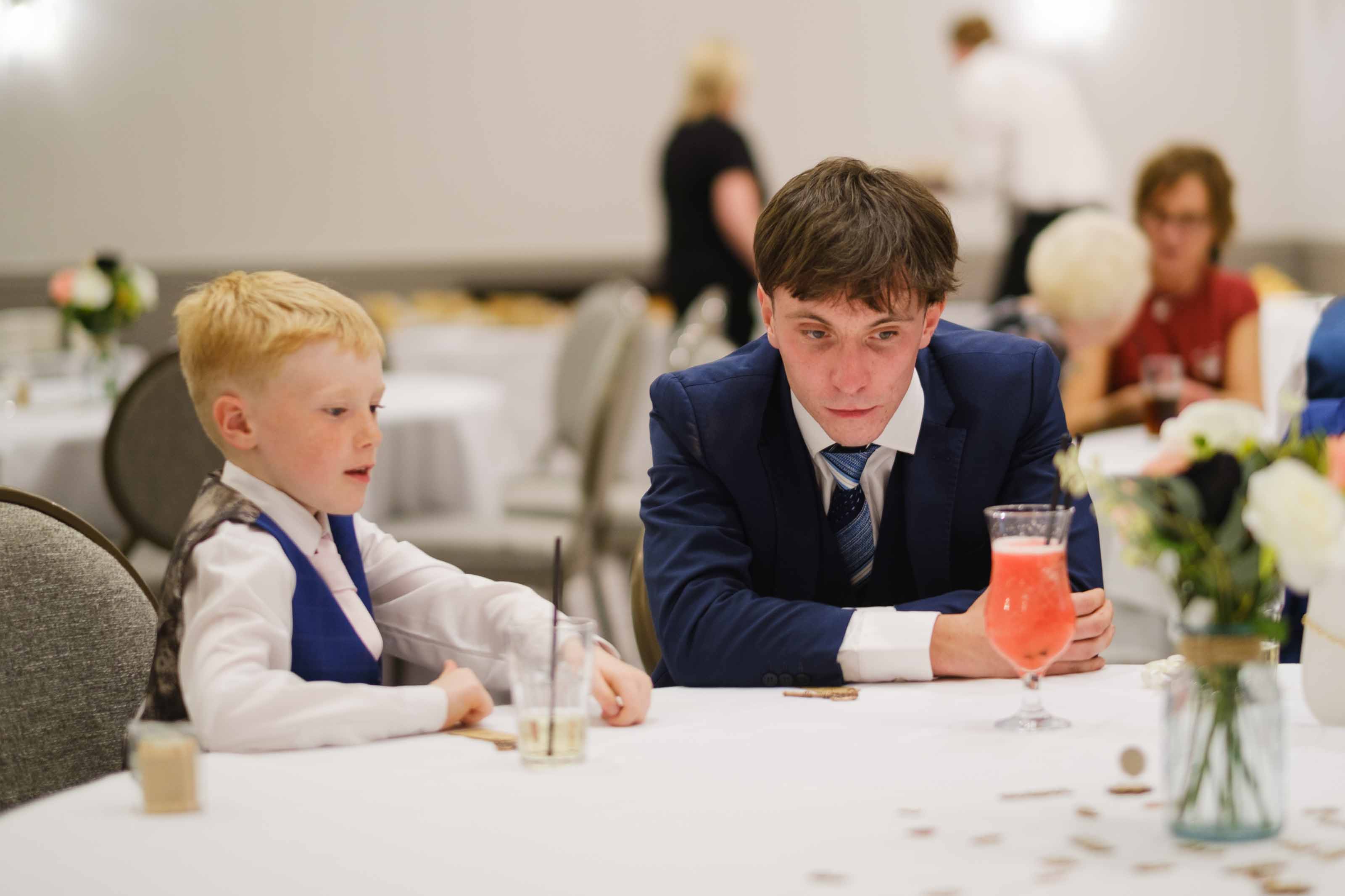 Wedding guest and child playing heads or tails during reception