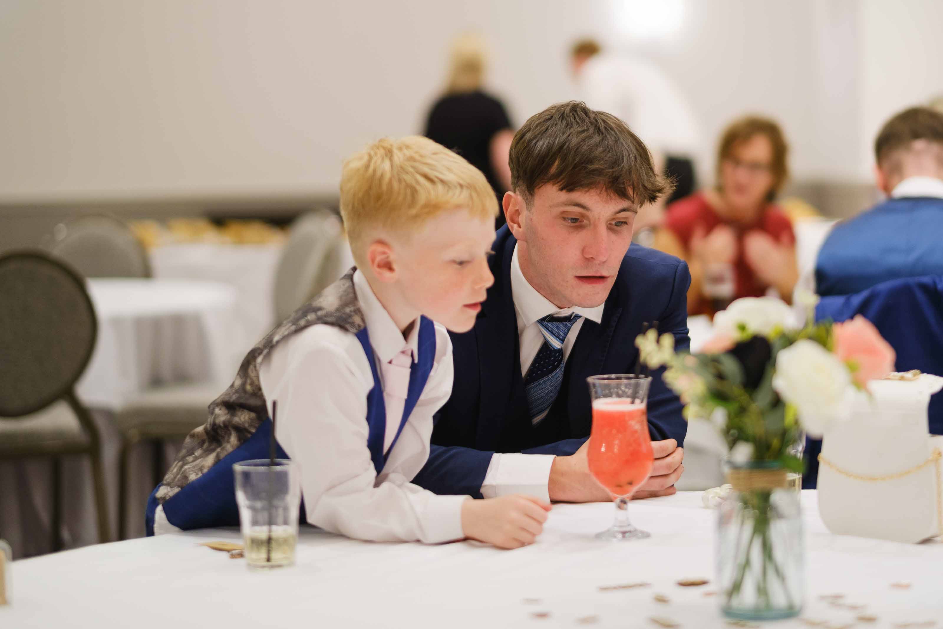 Wedding guest and child playing heads or tails during reception