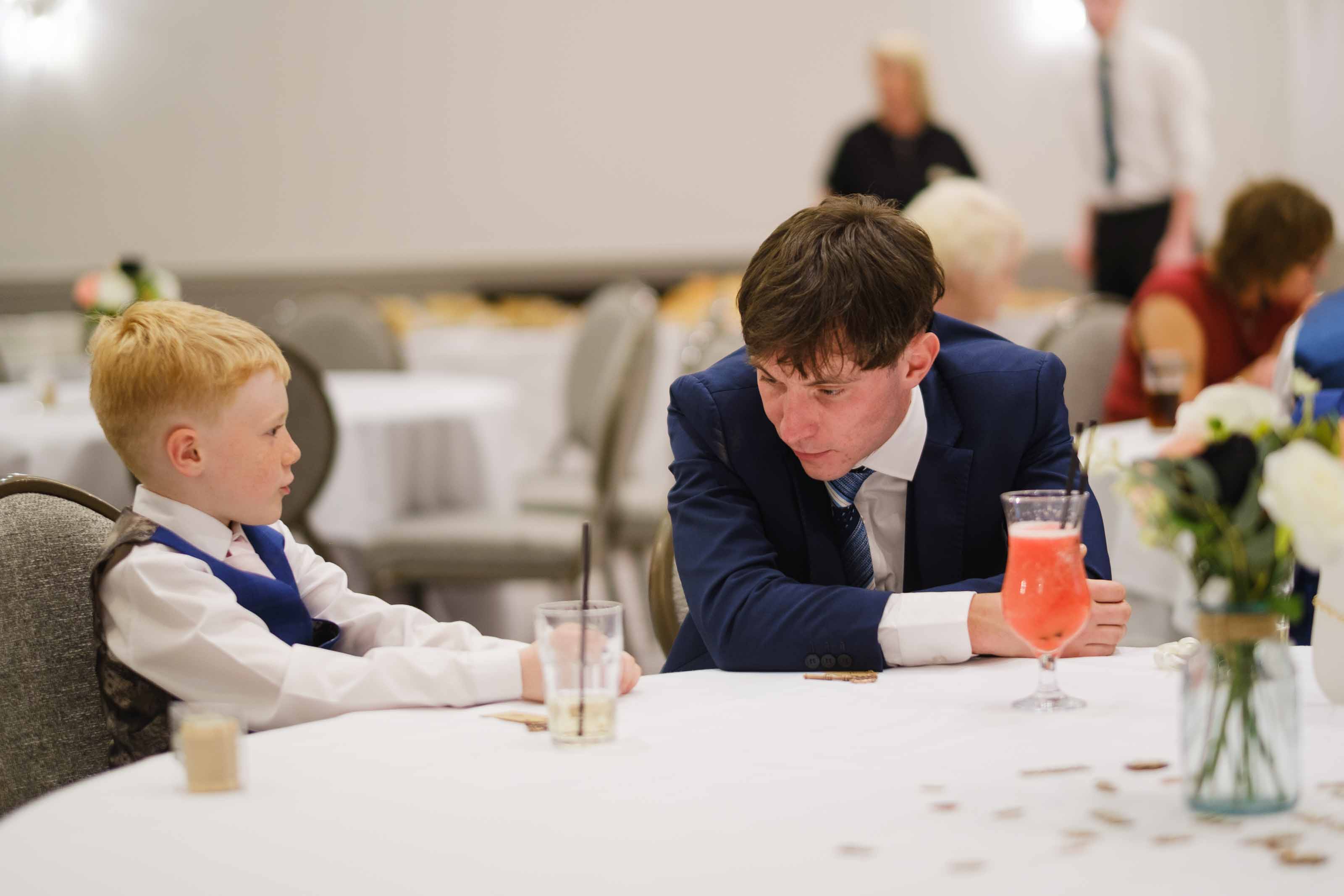 Wedding guest and child playing heads or tails during reception