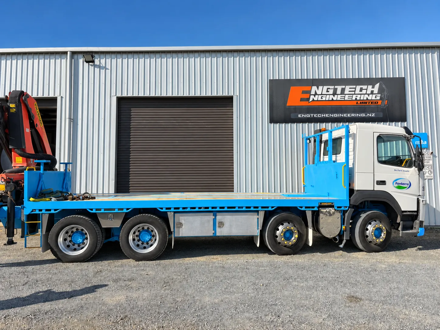 Blue truck body standing outside a workshop
