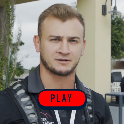 A man wearing a backpack stands next to a large red play button, symbolizing adventure and exploration in media.