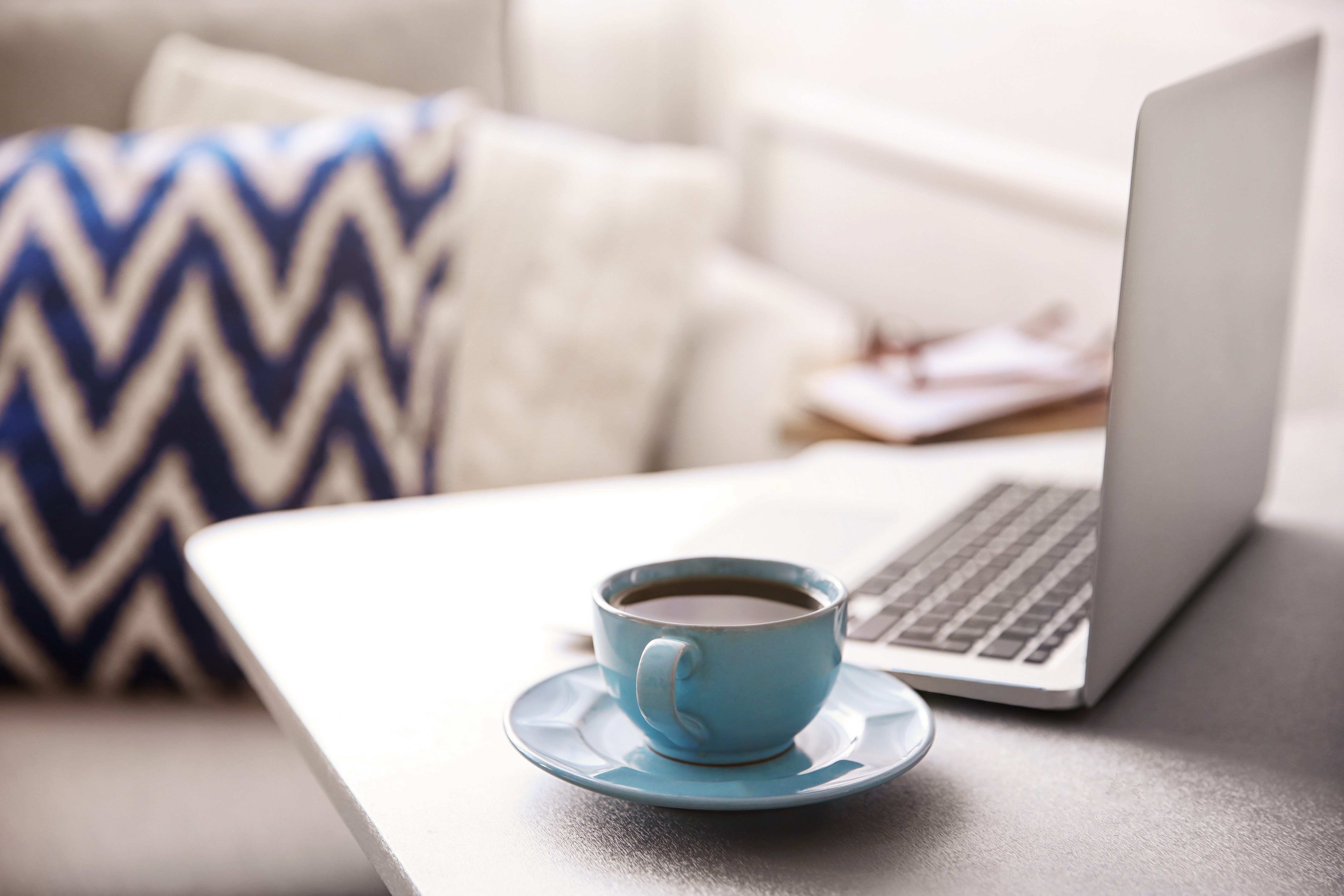coffee mug next to open laptop on table
