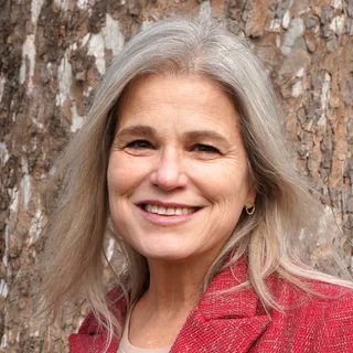Dr. Amy Taylor-Bianco, outdoors in front of a sycamore tree.