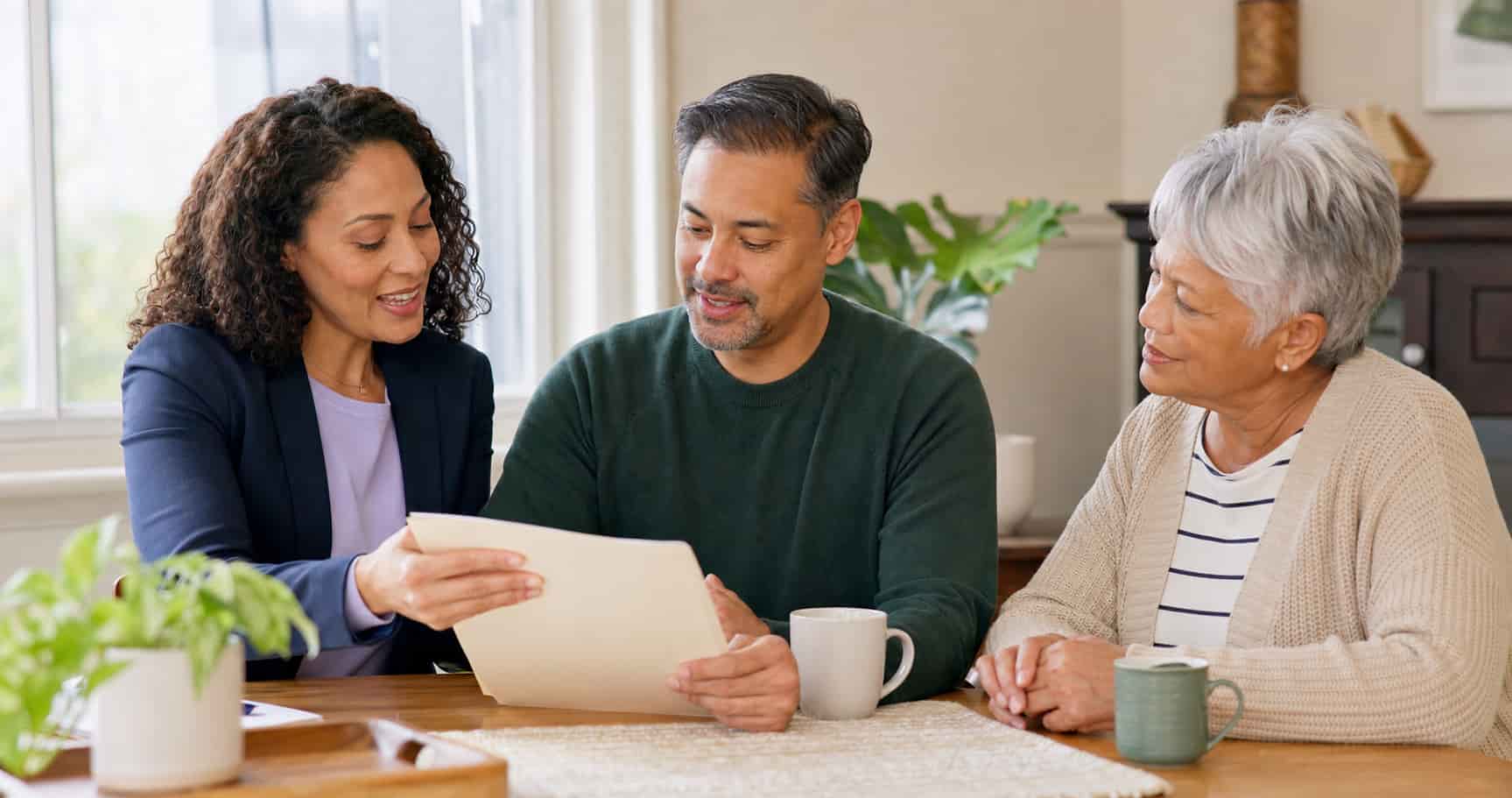 Family discussing paid caregiving options with a home care professional Family discussing paid caregiving options with a home care professional