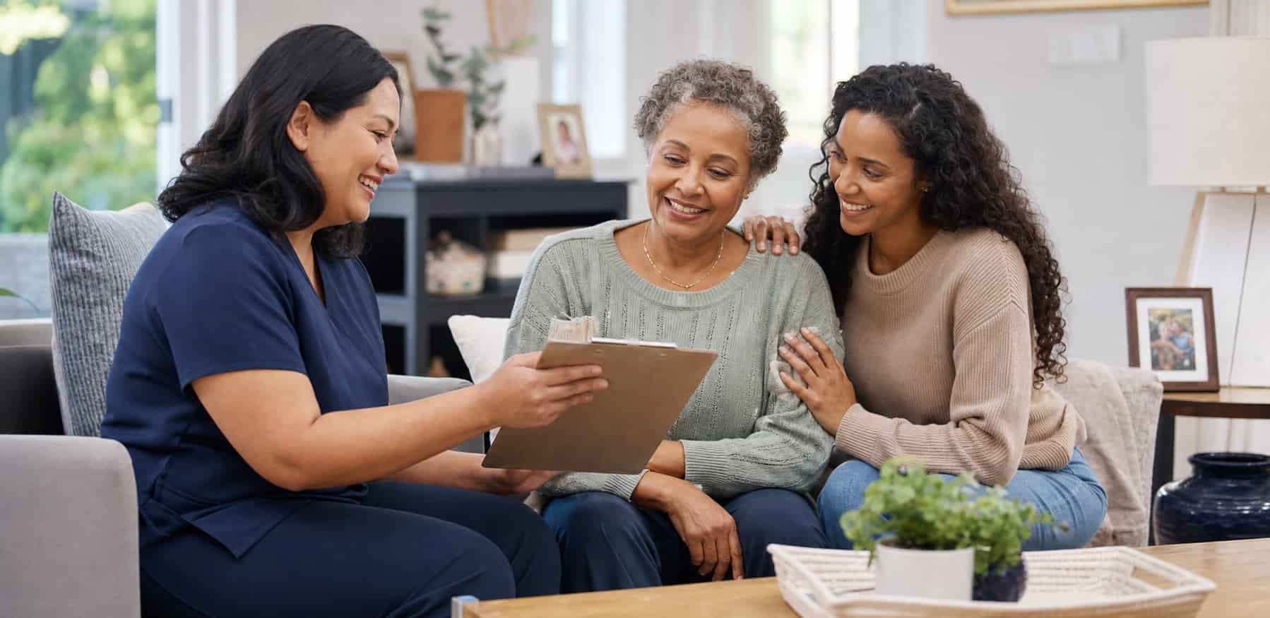 Care at Home caregiver reviewing a personalized home care plan with a senior and her family Care at Home caregiver reviewing a personalized home care plan with a senior and her family