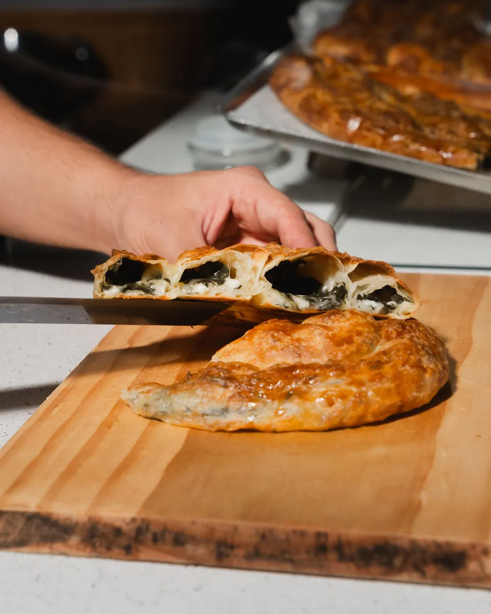 Spinach and feta börek cut open to show the green filling