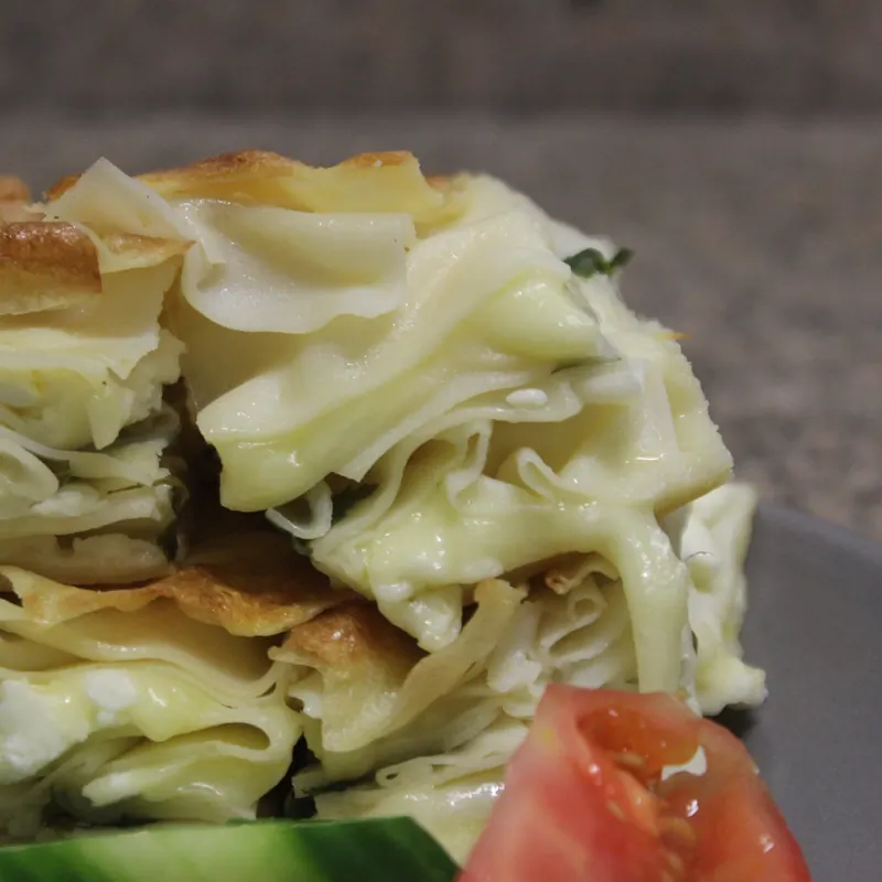 Soft, cheesy layers of su böreği with fresh tomato