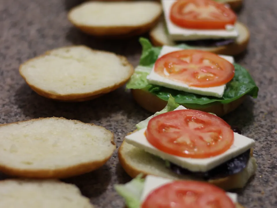 Fresh rolls laid out with feta, tomato and lettuce for a catering order