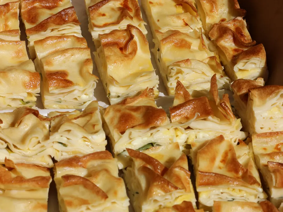 Box of golden cheese börek squares ready for delivery