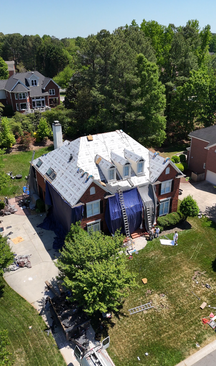Storm damage restoration in progress with full home wrap