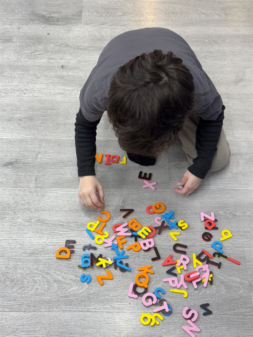 Niño jugando con letras magnéticas