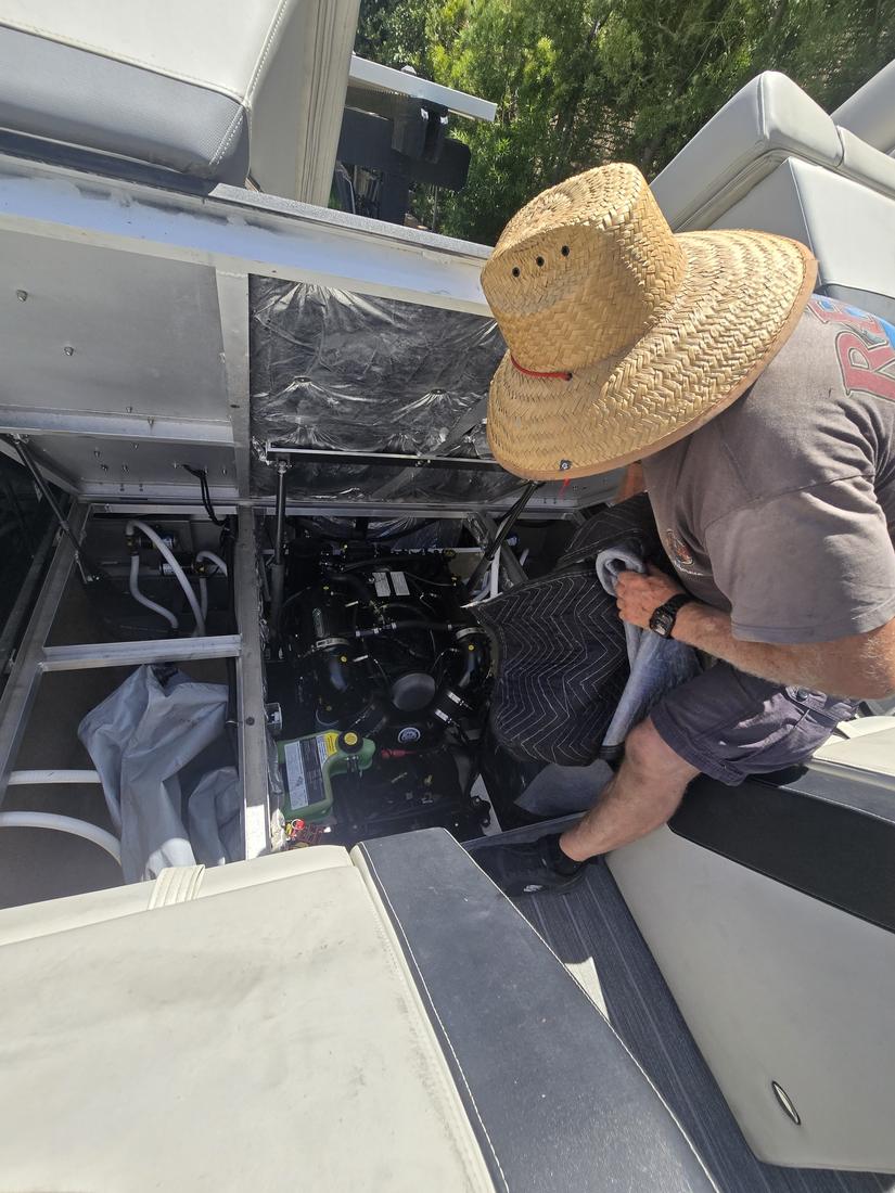 Technician servicing a boat engine bay