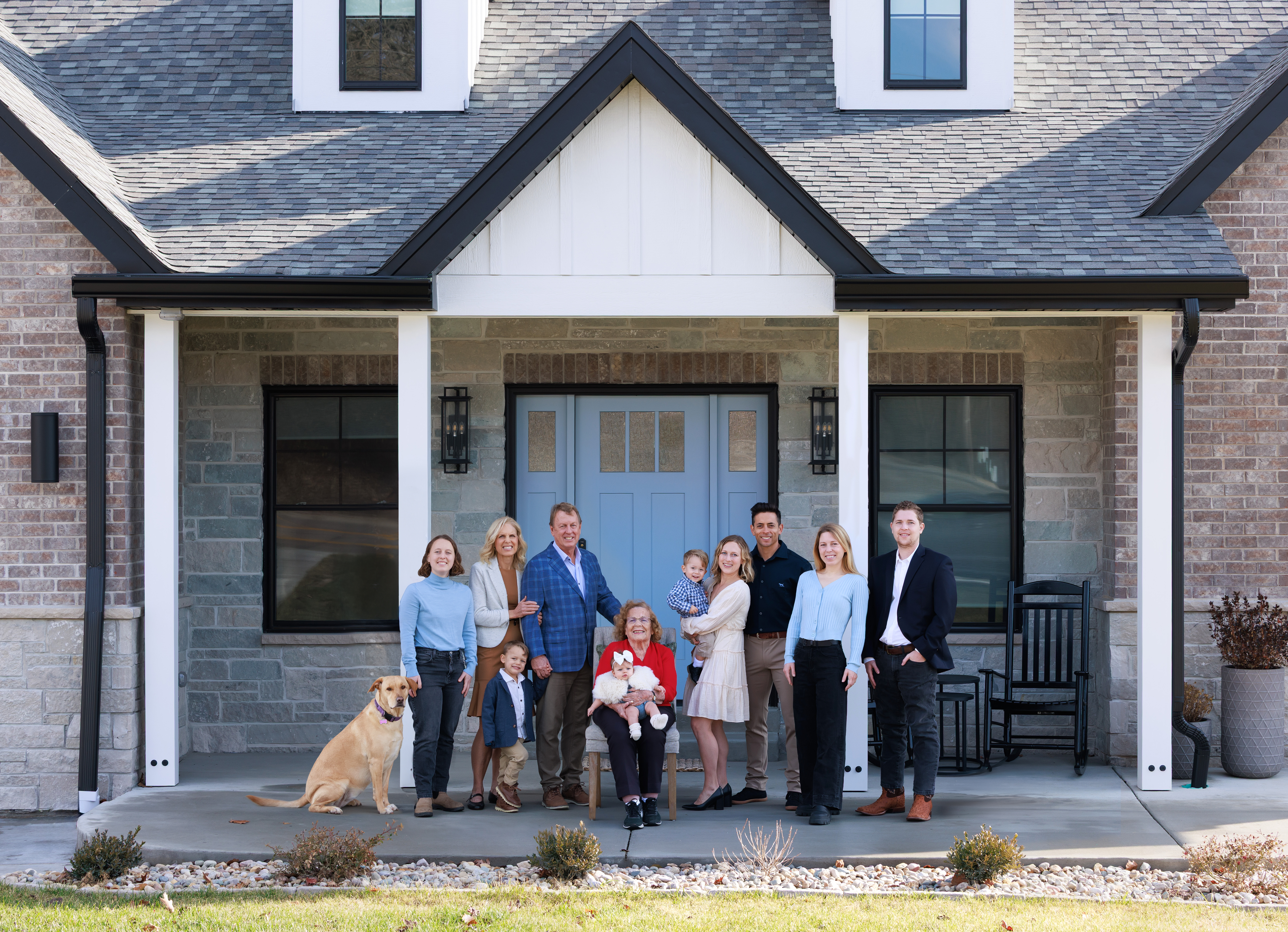 Multigenerational family and their dog gathered on the front porch of their home, St. Louis family photographer