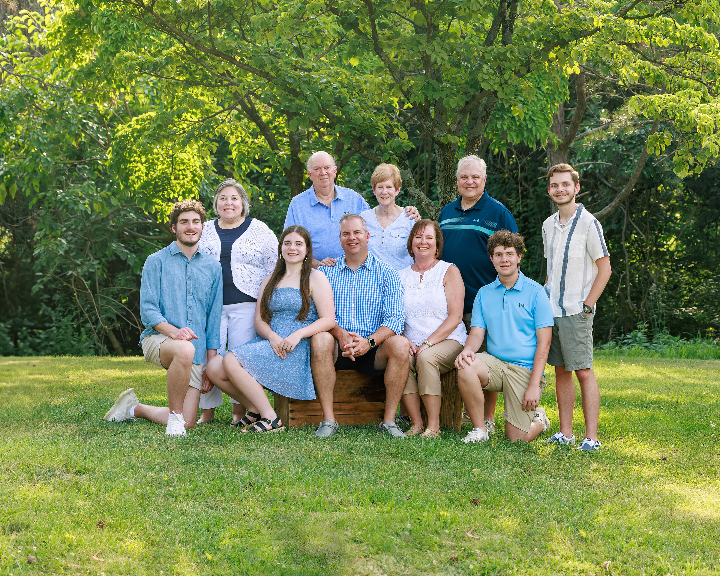 Three-generation family in coordinating blues posed under a large shade tree, St. Louis family photographer