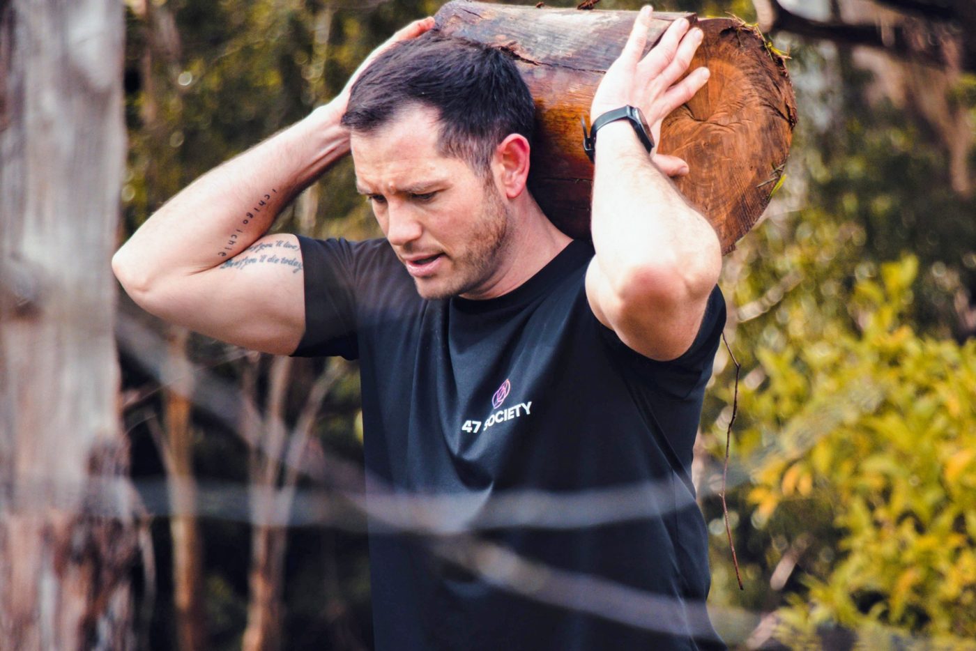 Sean Murray-Camp, founder of 47 Society, training outdoors with a log carry