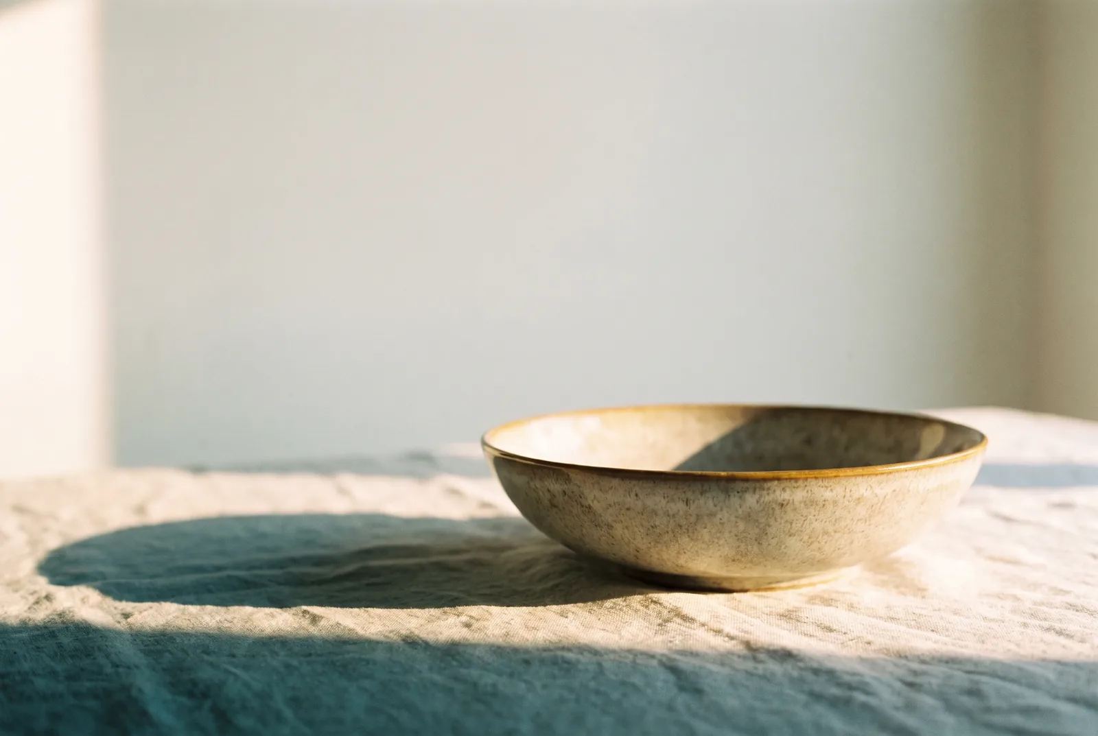 A single ceramic bowl on linen