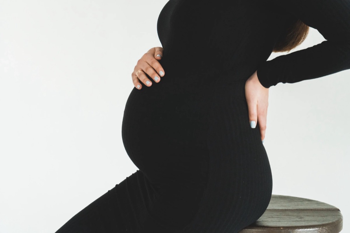 Pregnant woman holding her lower back