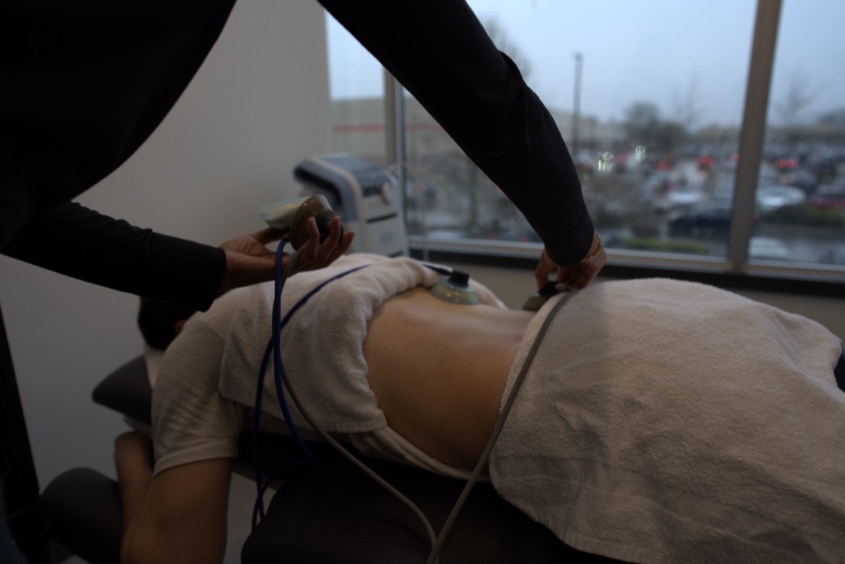 Shockwave treatment on a patient's back at Urban Wellness Clinic Langley