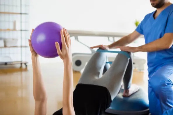 Physiotherapist guiding a patient through core strengthening at Urban Wellness Clinic
