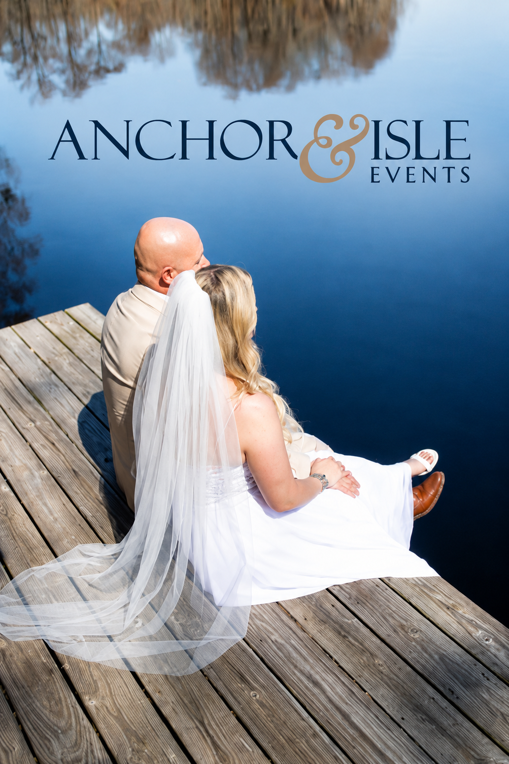 Couple in wedding attire seated together on a dock