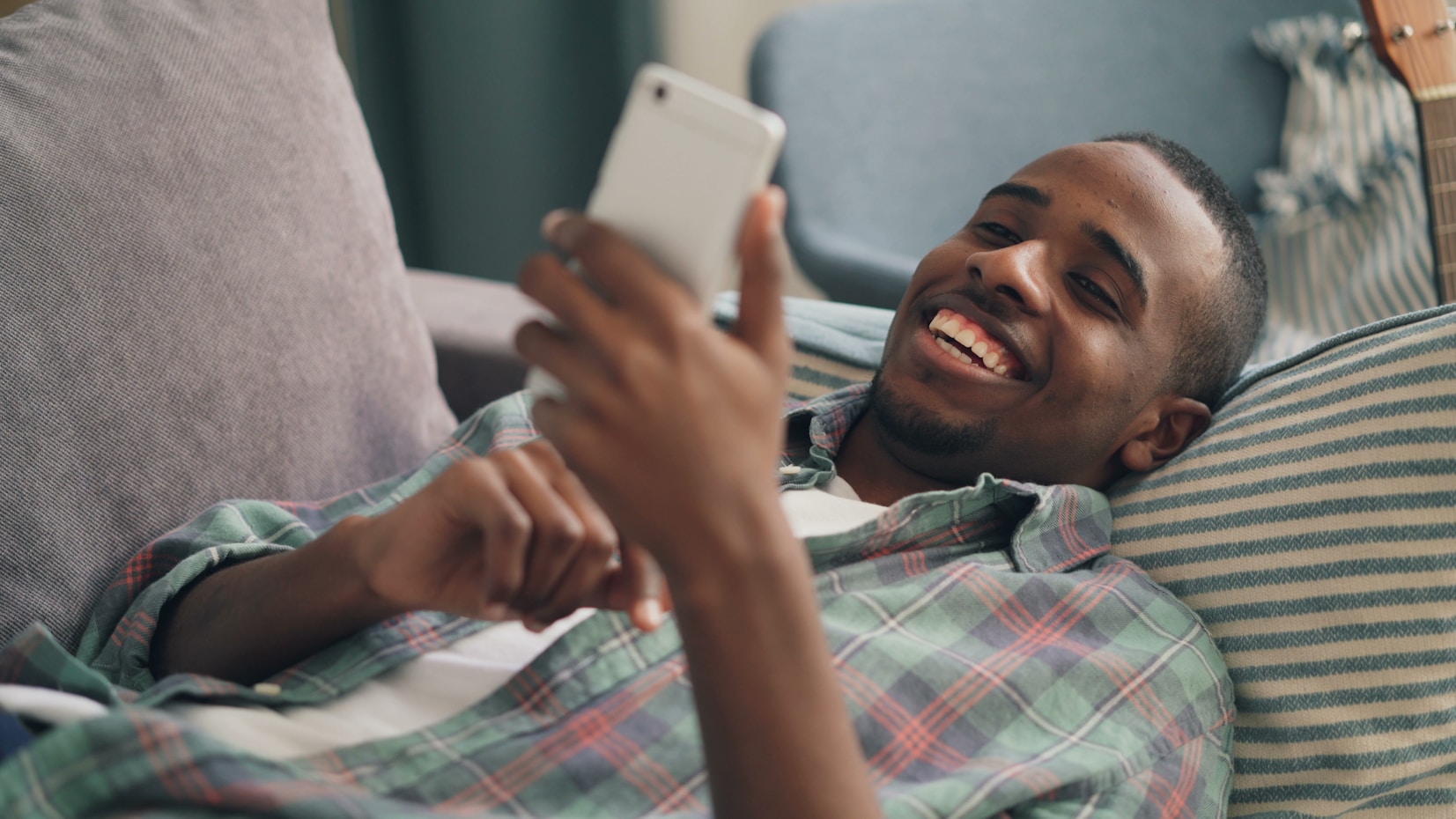 Creator relaxing on a couch checking their phone