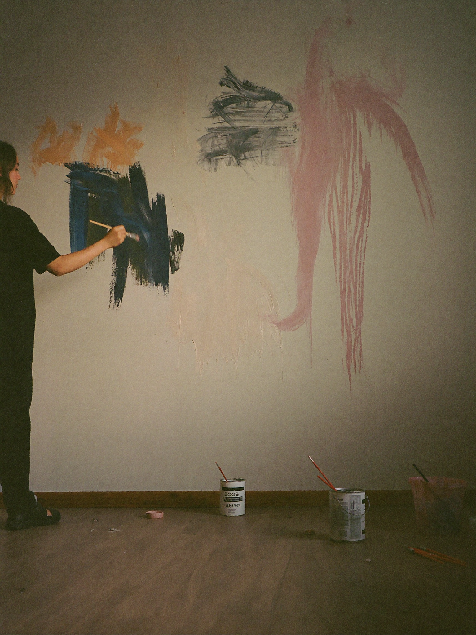 A student painting a mural in the arts studio