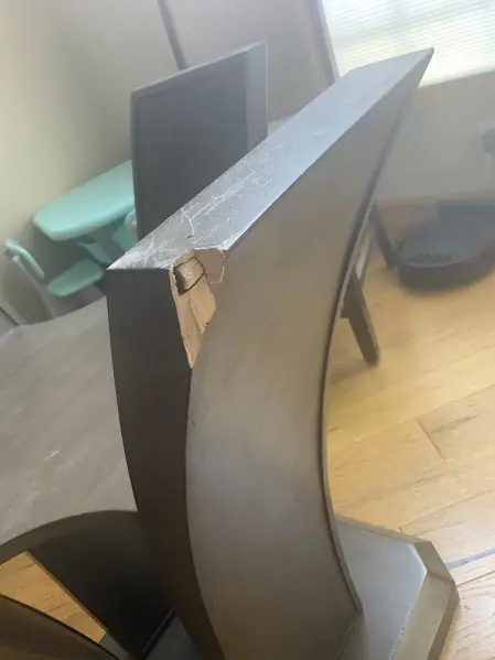 Before photo of a table base with a chipped corner, prior to repair.