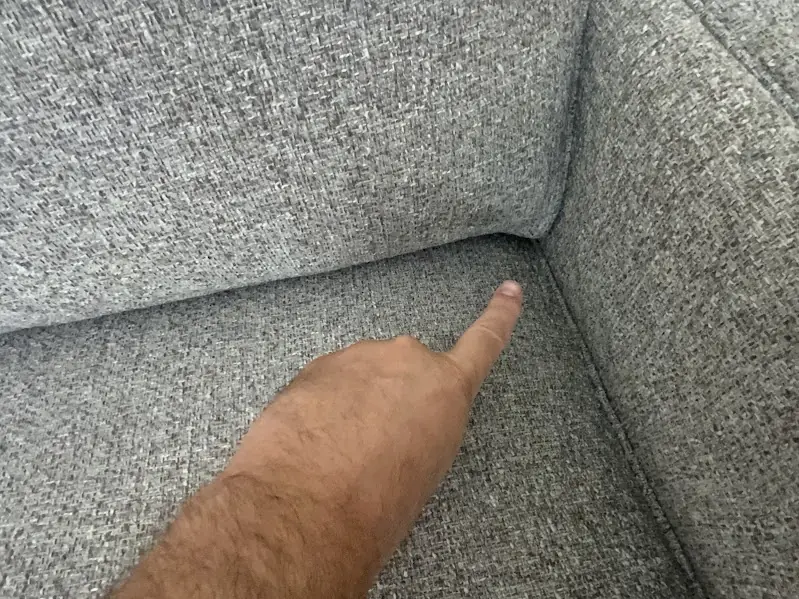 Before photo of a sectional with an open seam in the inside corner, prior to repair.
