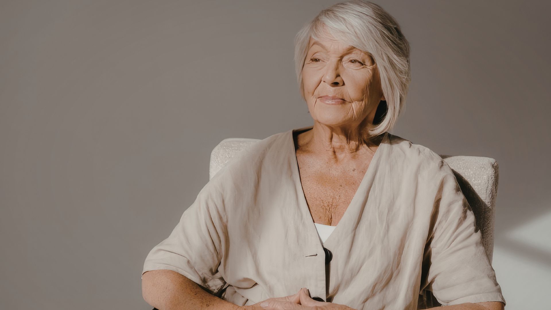 Midlife woman sitting quietly with hands over heart representing the gentle process of reconnecting with herself and rebuilding self trust. Midlife woman sitting quietly with hands over heart representing the gentle process of reconnecting with herself and rebuilding self trust.