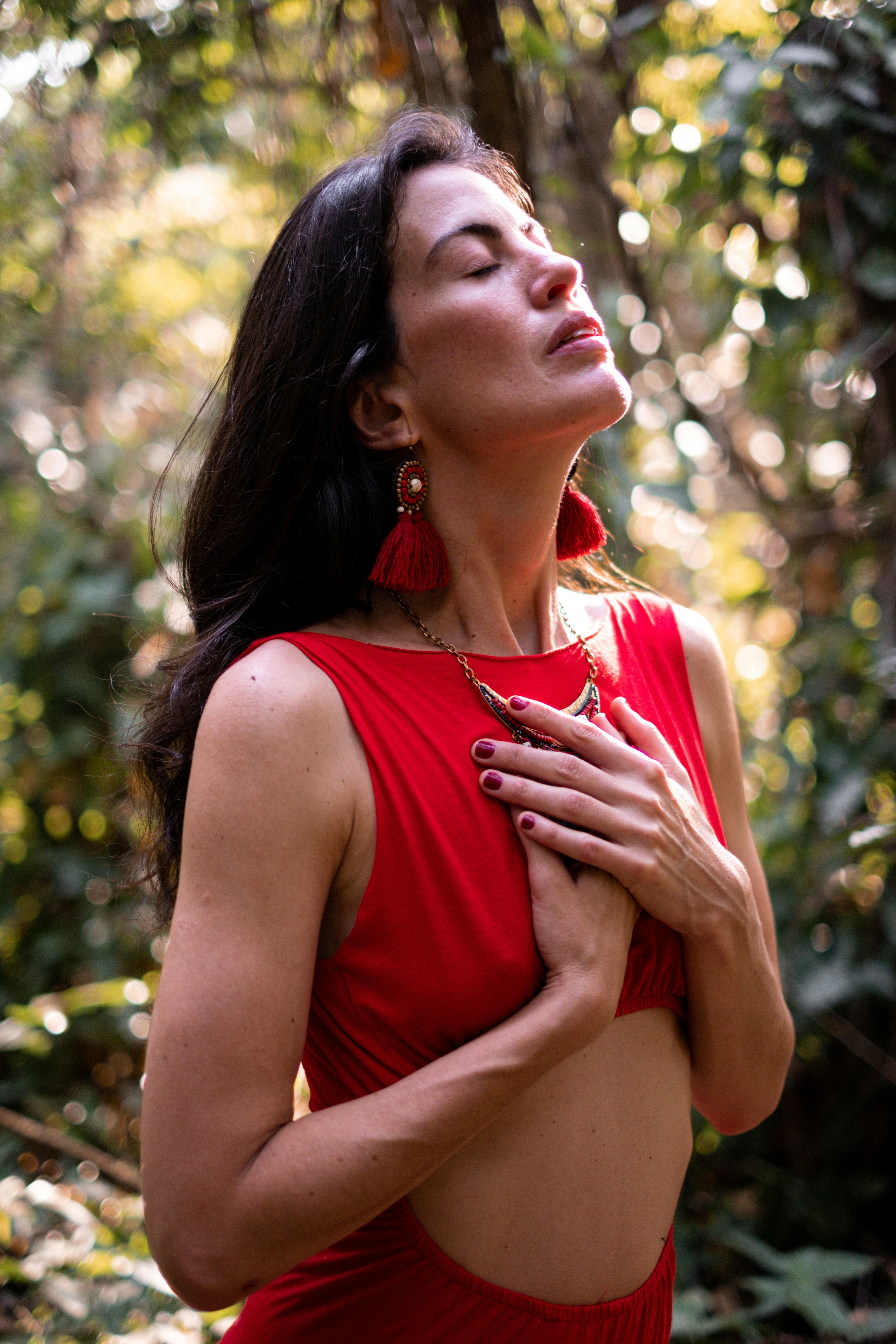 Woman with hands over heart in a quiet moment representing the physical sensation of tuning into intuition rather than reacting to fear. Woman with hands over heart in a quiet moment representing the physical sensation of tuning into intuition rather than reacting to fear.