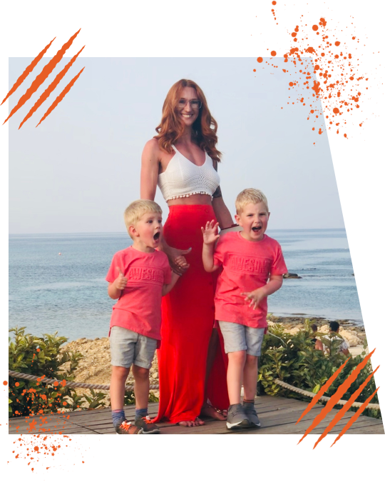 Woman enjoying time with her two young children by the seaside, showcasing her family-focused lifestyle and personal fitness journey.
