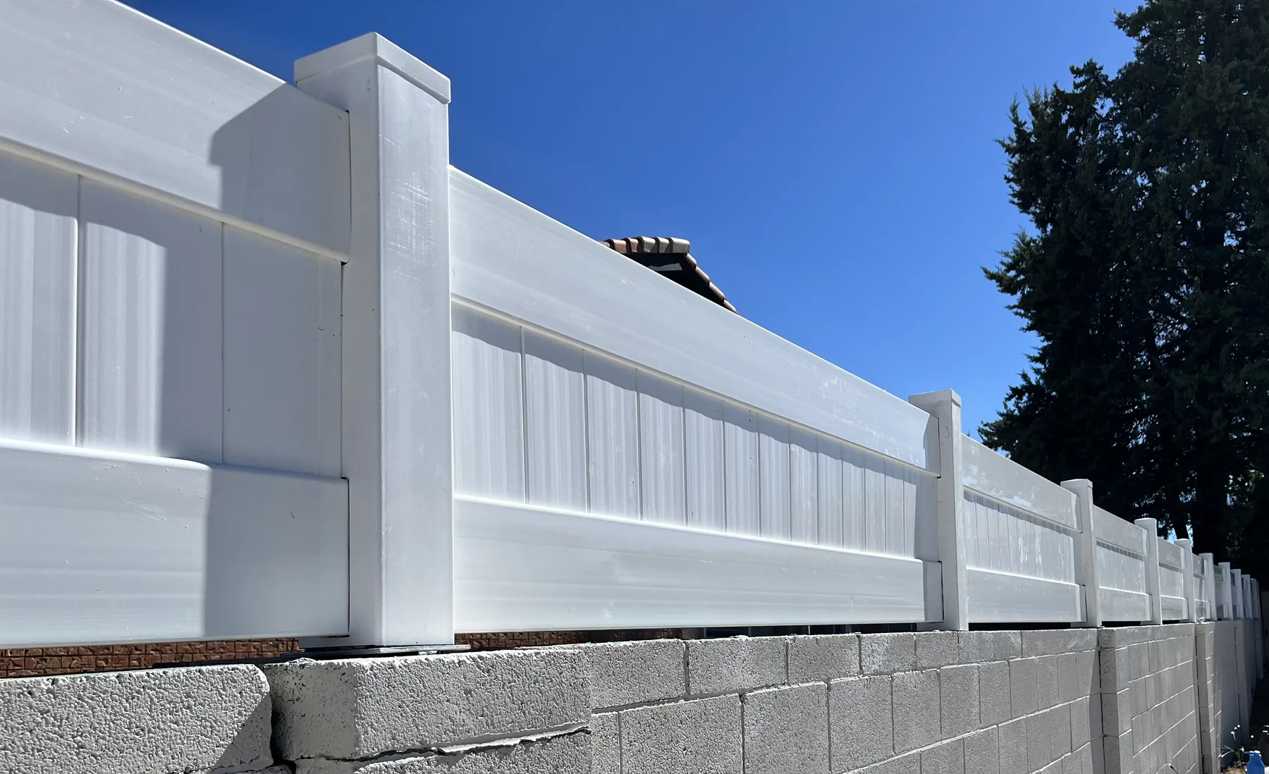 White privacy fence on a block wall