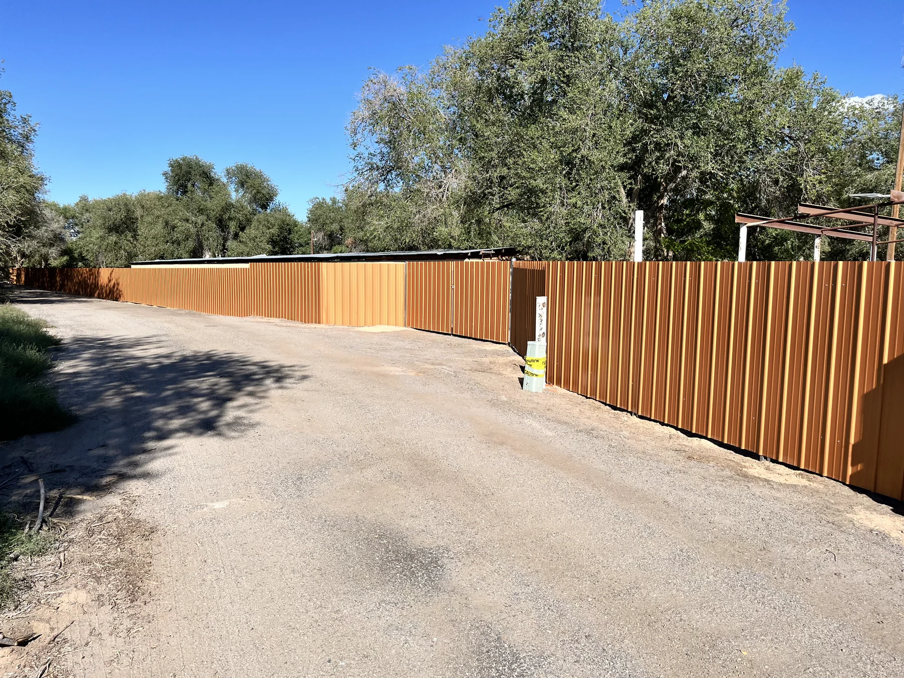 Long finished fence along a paved drive