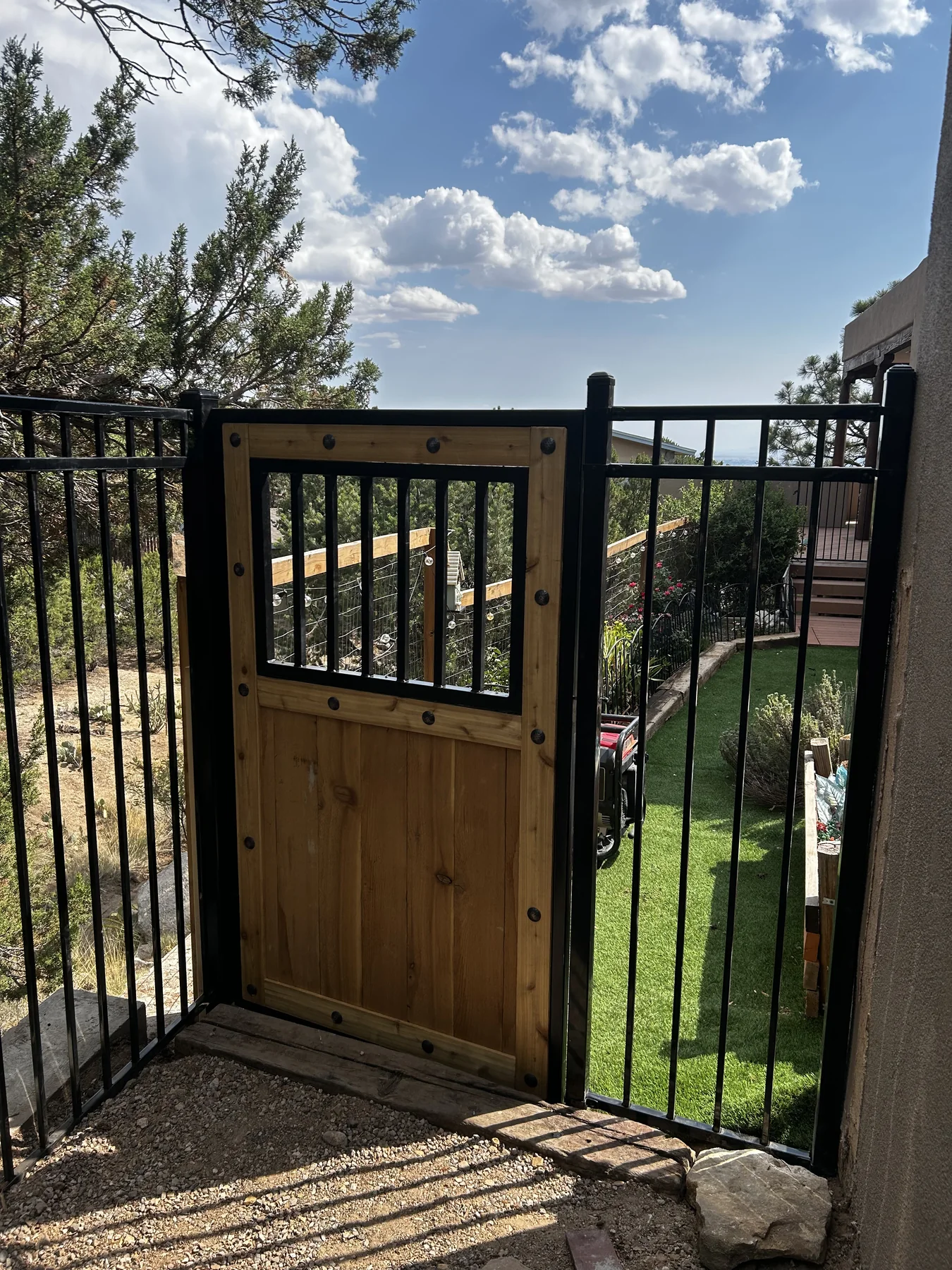 Decorative metal gate with a wood center panel