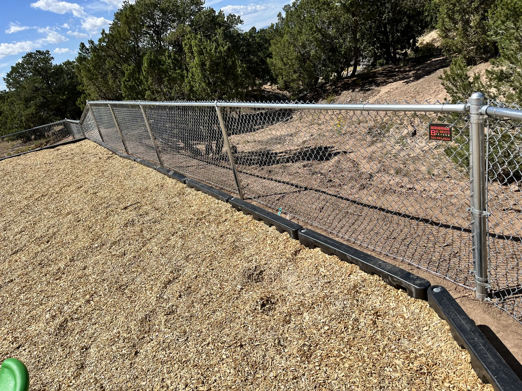 Chain-link fence following a sloped property line