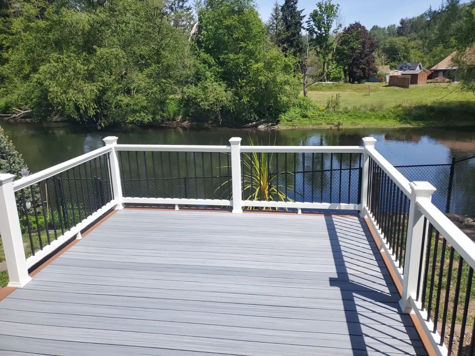 Finished deck with dark railings overlooking a landscaped outdoor area