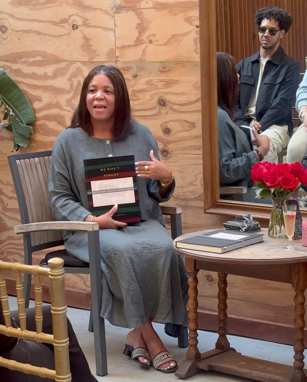 Trivia Thomas at her book release party holding We Won't Forget