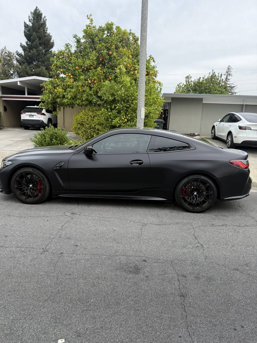 Matte black BMW M4 Competition side