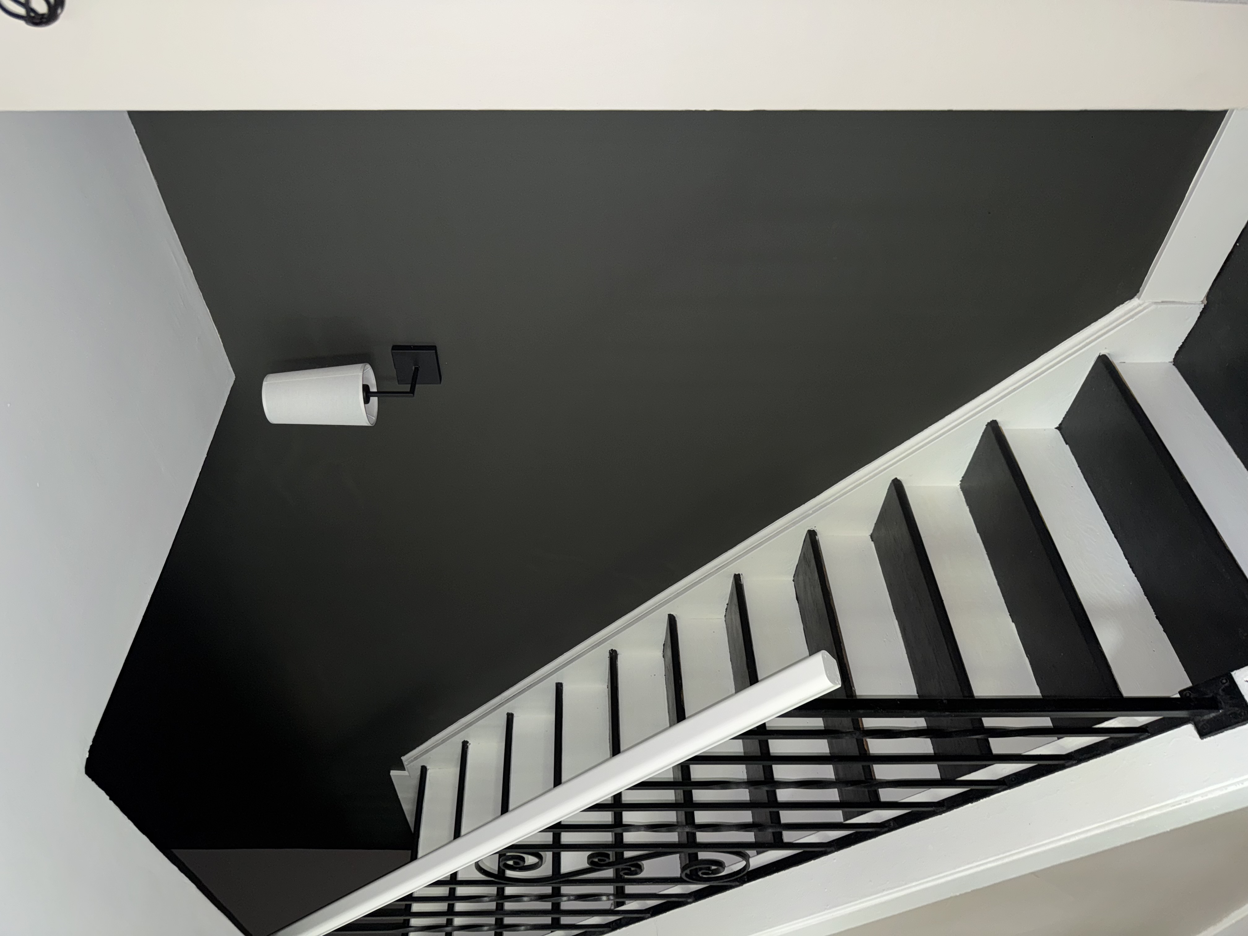 Dark green painted staircase with white trim by Premier Pro Painting in Waterloo Region