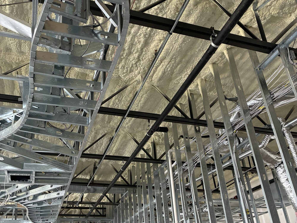 Steel stud framing and spray-foam ceiling inside a new commercial build