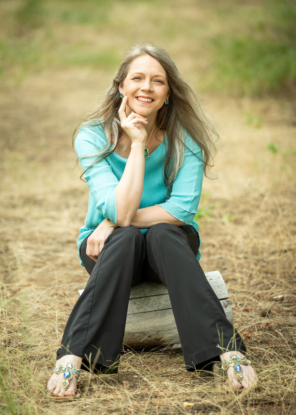 Sherilyn S. Long, Master Herbalist and author, seated in blue, smiling and looking at the camerabalist