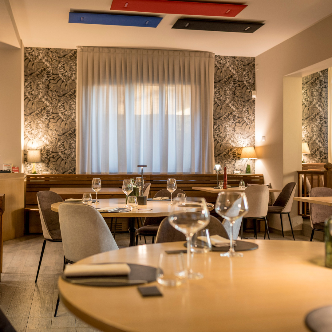 La sala intima del Convivio, con le luci calde, i calici e i tavoli pronti per gli ospiti