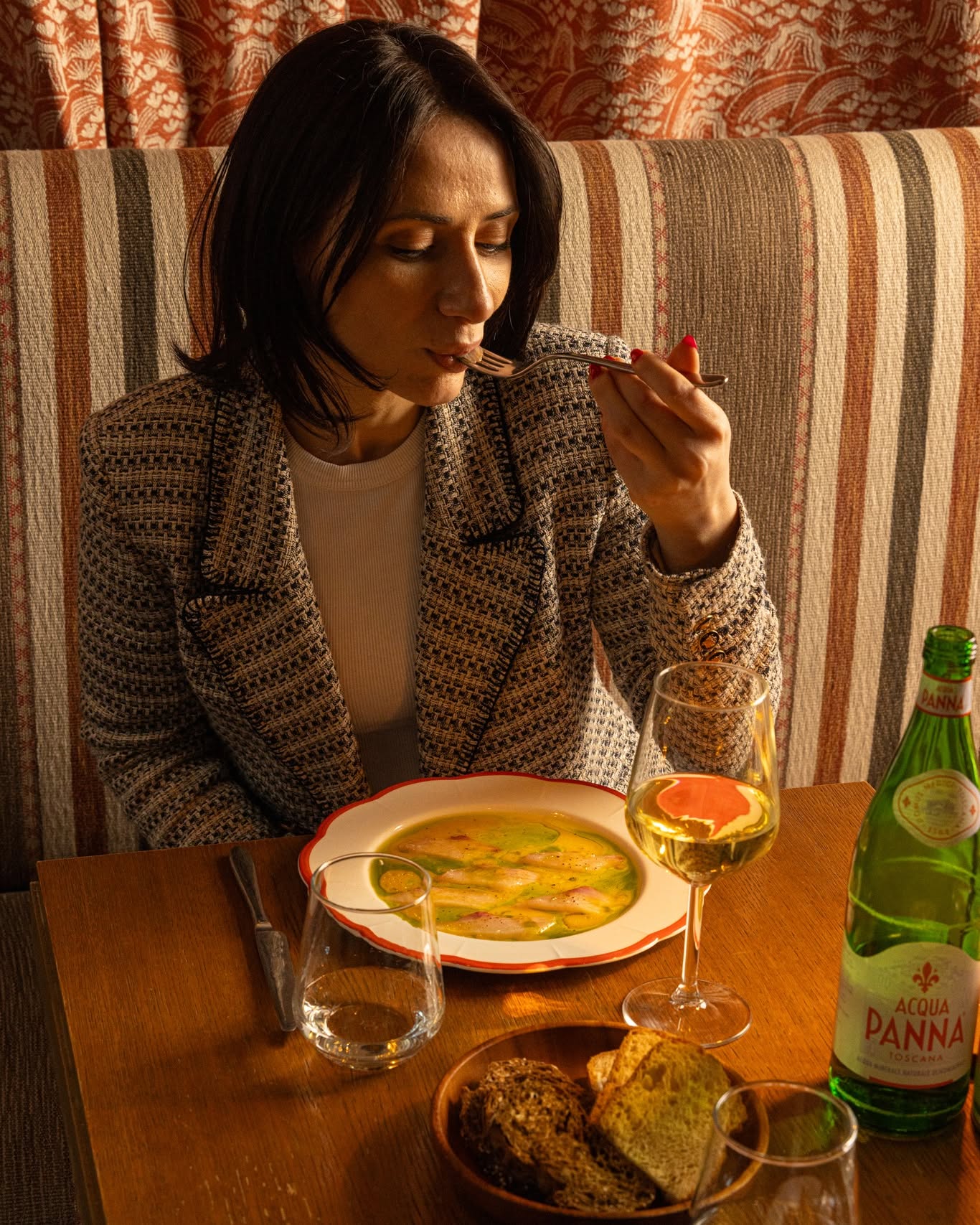 Un’ospite a cena tra calici e sedute della Maison