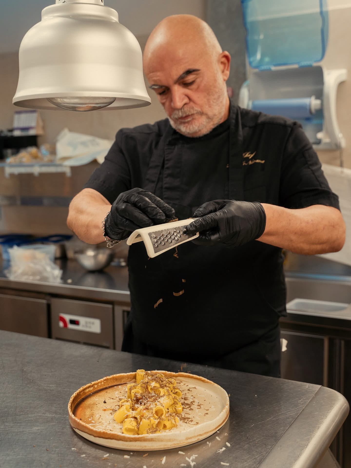 Lo chef del Ristorante MO aggiunge il tartufo a un piatto di pasta