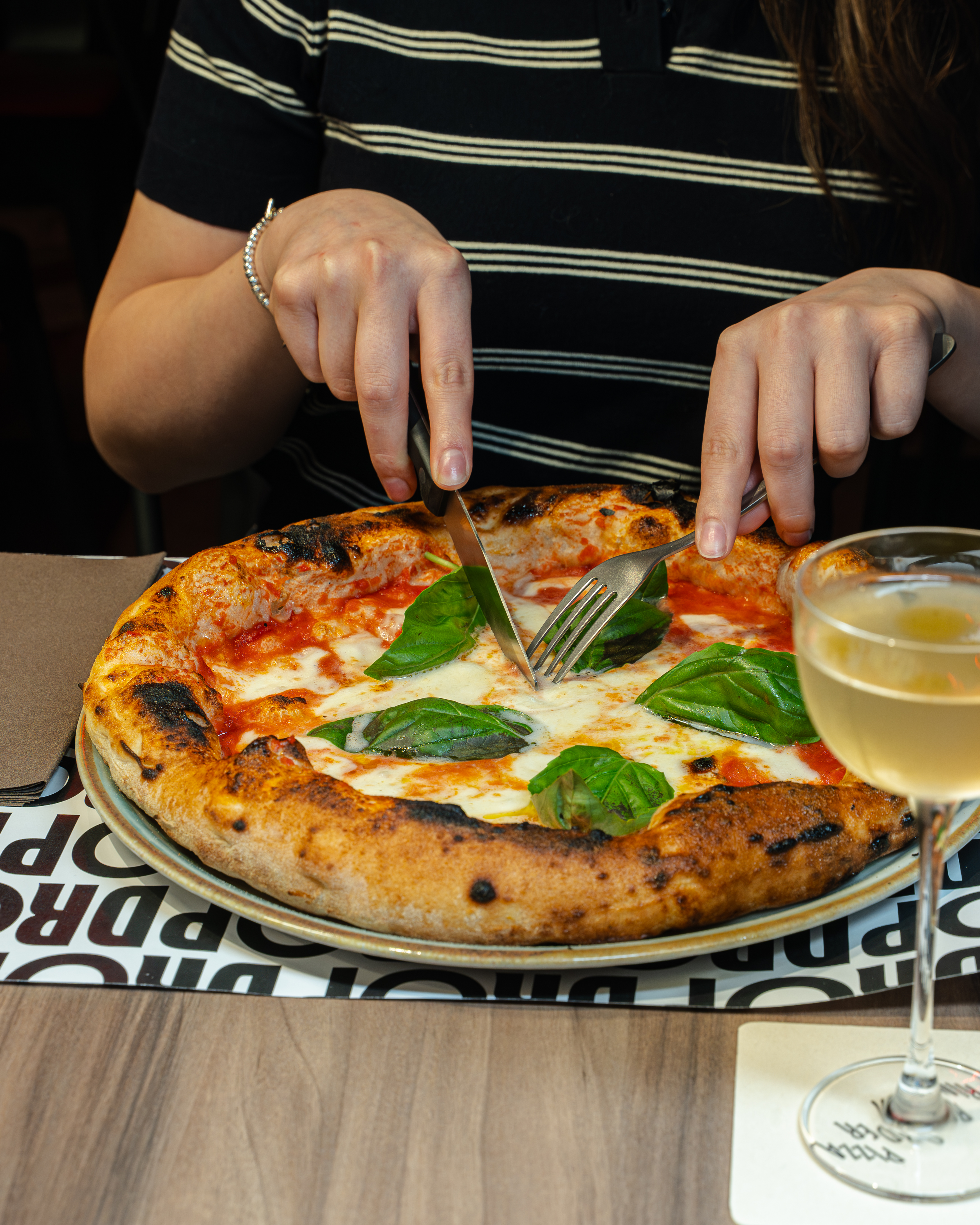 Una pizza contemporanea appena servita, da gustare con un cocktail al tavolo di DROP