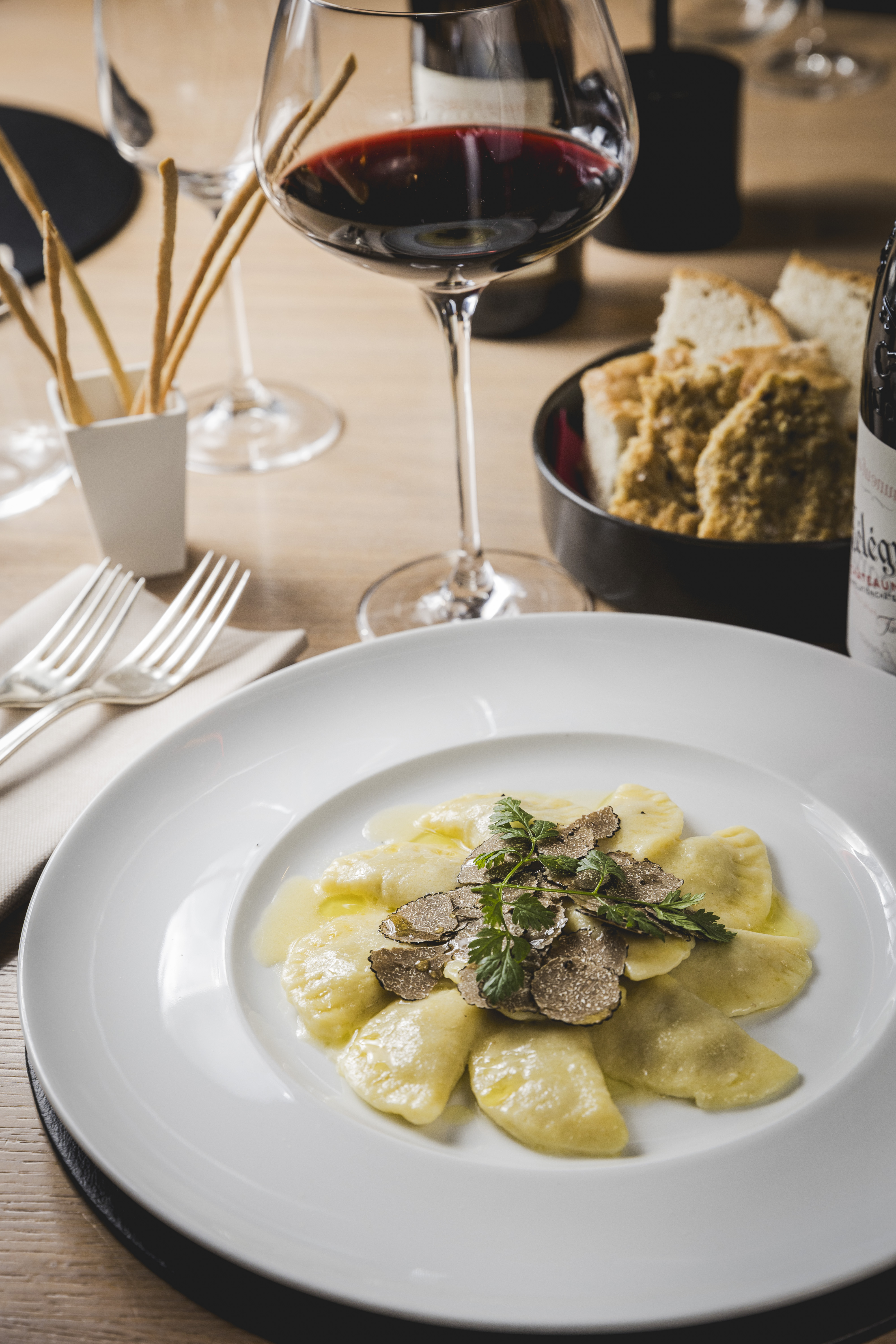 Un piatto di pasta del Convivio, con un calice di vino rosso e pane in tavola