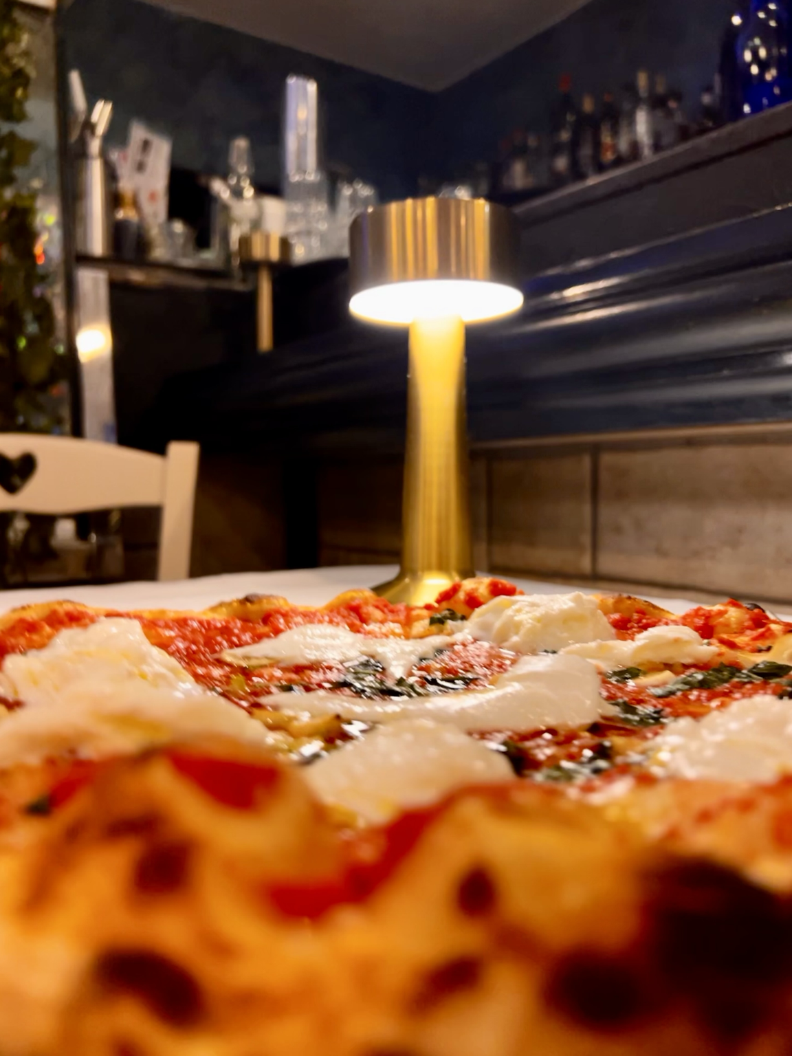 Una pizza Sanfy sulla tavola illuminata da una lampada